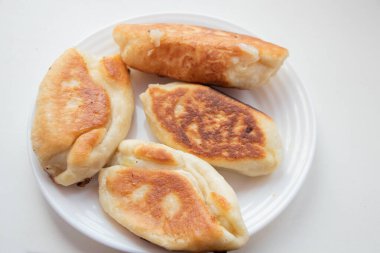 Kızarmış börekler beyaz arka planda bir tabakta