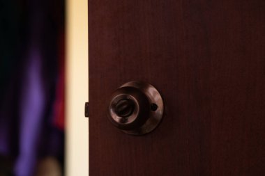 Karanlık bir odada yuvarlak saplı bir kapı.