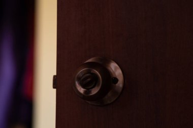 Karanlık bir odada yuvarlak saplı bir kapı.