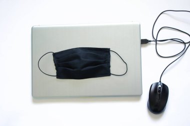 Siyah tıbbi maske ve dizüstü bilgisayar, karantina işi