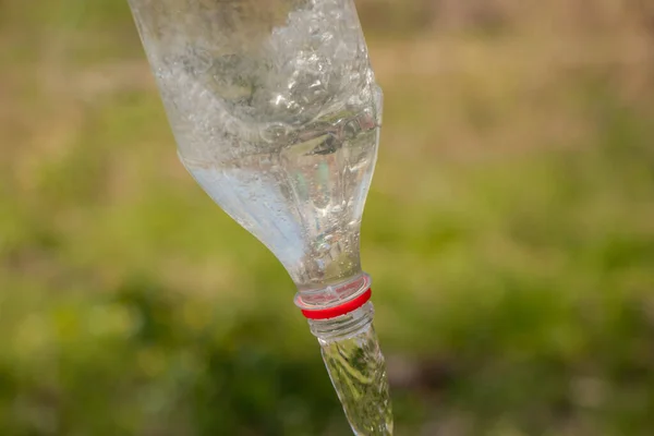 Water Pouring Plastic Bottle Blurred Green Background Street — Stock Photo, Image