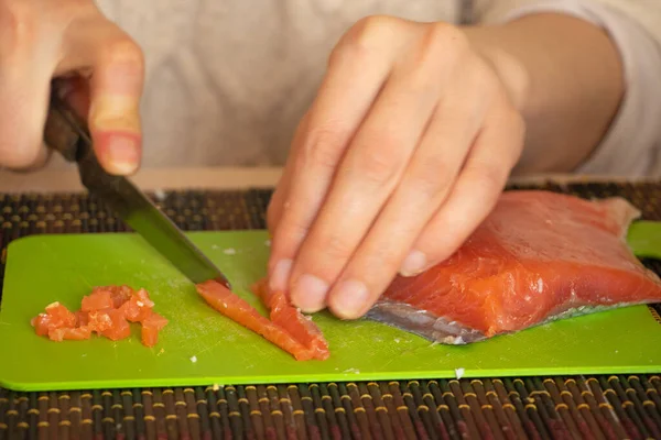 Vrouwelijke Hand Gesneden Zalm Salade Een Groen Bord Keuken — Stockfoto