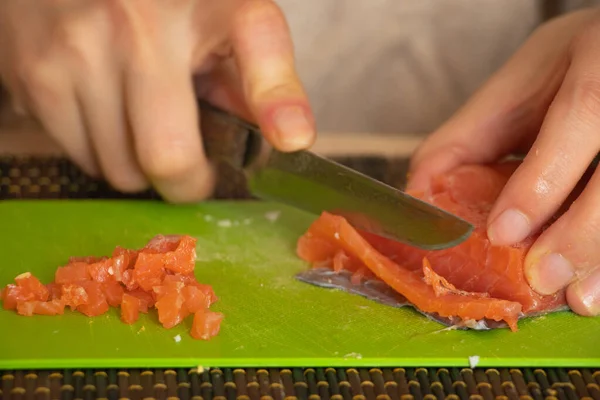 Vrouwelijke Hand Gesneden Zalm Salade Een Groen Bord Keuken — Stockfoto