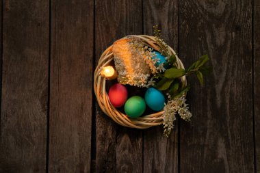 Paskalya yemeği, renkli tavuk yumurtası ve mum alevi eski ahşap bir masada akşam yemeği.