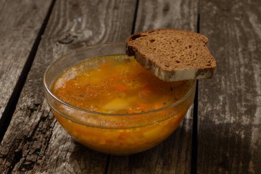 Bezelye çorbası ve tahtadan bir masada bir dilim kahverengi ekmek.