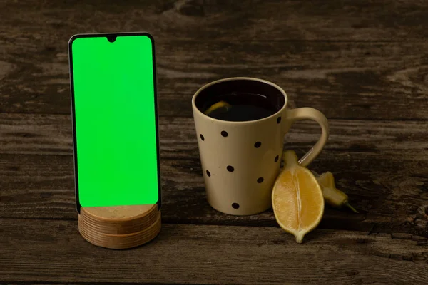 Mobiltelefon Mit Grünem Bildschirm Und Einer Tasse Tee Mit Zitrone — Stockfoto
