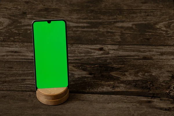 Telefon Zielonym Ekranem Leży Drewnianym Stole — Zdjęcie stockowe