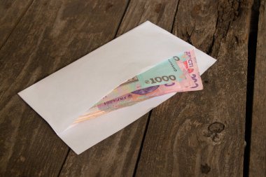 Ukrayna nakit para birimi ahşap bir masada beyaz bir zarfın içinde, maaşı da bir zarfın içinde.