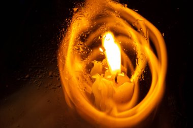 Karanlık bir odada bir kilise mumunun alevi