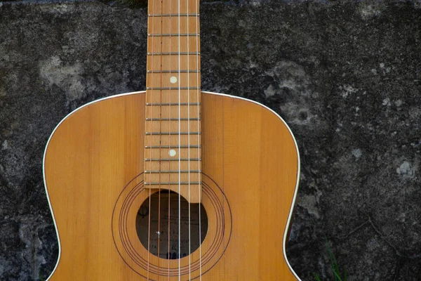 木製の茶色のギターは春の草の中の通りの石の道にあり — ストック写真