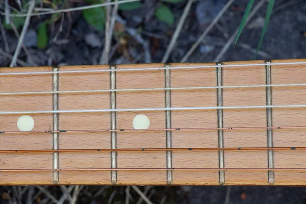 木製の茶色のギターは春の草の中の通りの石の道にあり — ストック写真