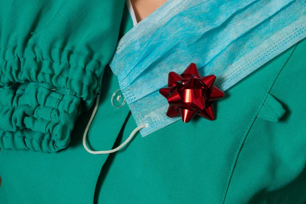 Одяг медсестри в україніанській лікарні на ізольованому фоні з близьким планом і з червоним подарунком. — стокове фото
