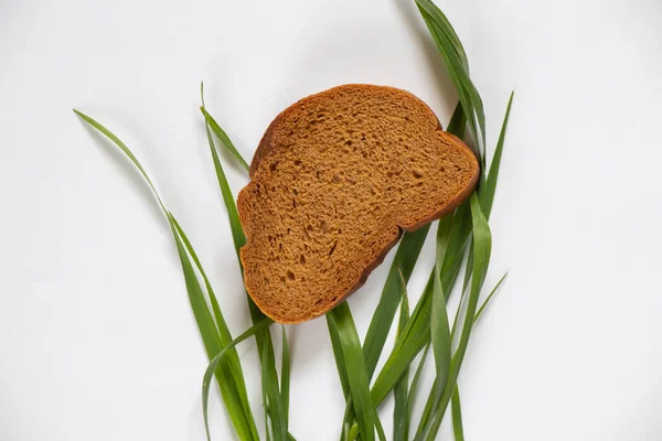 Gras Een Stuk Bruin Brood Een Witte Achtergrond Close — Stockfoto