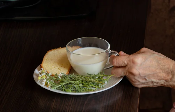 Стара Рука Тримає Чашку Молока Біля Ромашок Шматочок Хліба Столом — стокове фото