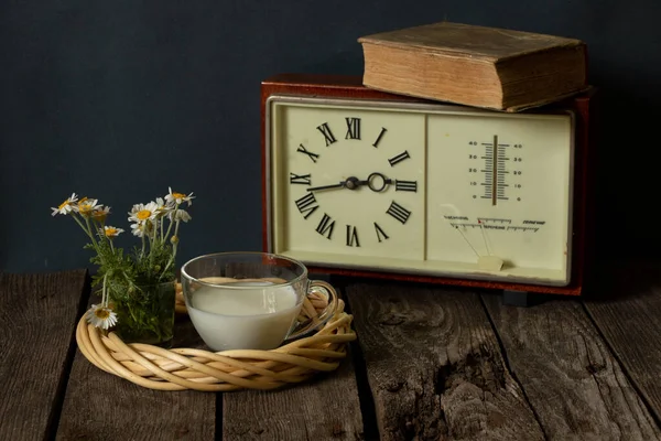 Xícara Leite Vaso Com Margaridas Perto Relógio Com Livro Uma — Fotografia de Stock
