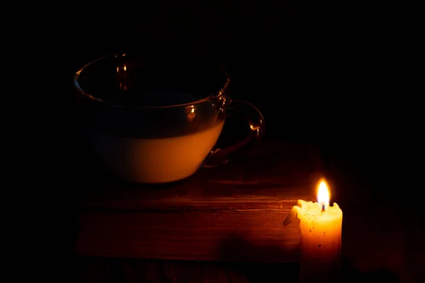 Kerzenflamme Und Tasse Mit Milch Und Einem Buch Auf Einem — Stockfoto