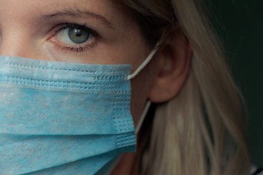 2020 'deki karantina salgını sırasında yüzünde tıbbi maske olan genç bir Ukraynalı kadının resmi.