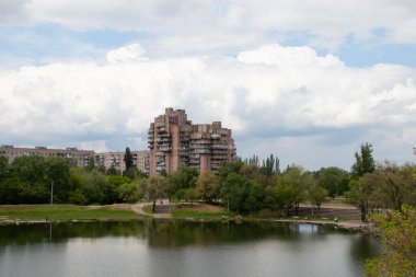 Ukrayna 'daki kırmızı taştan konut arazisindeki bir taş ocağının arka planındaki çok katlı bina.