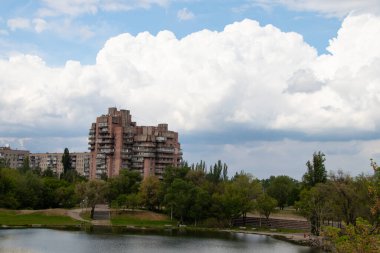 Ukrayna 'daki kırmızı taştan konut arazisindeki bir taş ocağının arka planındaki çok katlı bina.