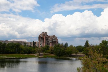 Ukrayna 'daki kırmızı taştan konut arazisindeki bir taş ocağının arka planındaki çok katlı bina.
