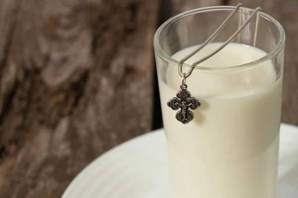 Silberkreuz Und Ein Glas Voll Milch Auf Einem Holztisch — Stockfoto