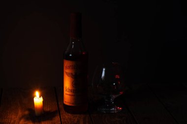 Ukrayna, Dnipro - Nisan 06, 2020. Bodrumda bulunan üçüncü Reich 'ın Horneburger 1939 viskisi evin karanlık bir odasında mumların yanında duruyor.