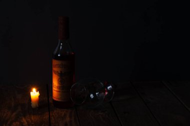 Ukrayna, Dnipro - Nisan 06, 2020. Bodrumda bulunan üçüncü Reich 'ın Horneburger 1939 viskisi evin karanlık bir odasında mumların yanında duruyor.