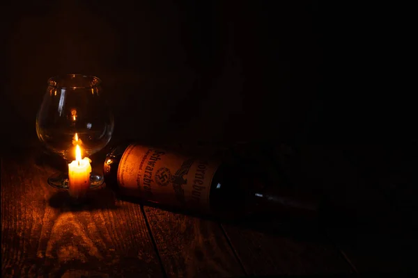 乌克兰 第聂伯鲁 2020年4月6日1939年在地下室发现的第三帝国的角形汉堡威士忌在屋子黑暗的房间里 烛光旁边立着蜡烛 — 图库照片