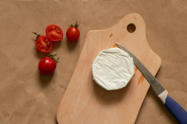 Yumuşak brie peyniri yalan söyler ve masada vişneli domates