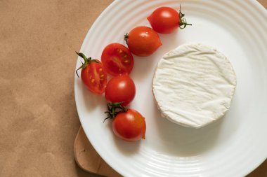 Yumuşak brie peyniri yalan söyler ve masada vişneli domates