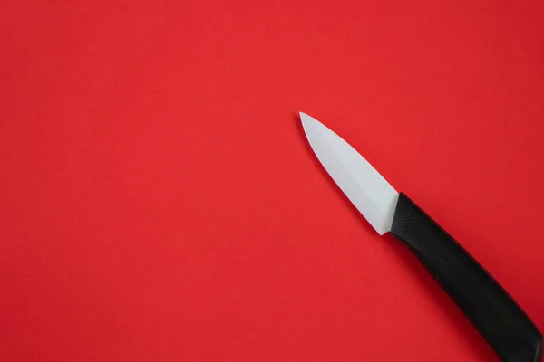 隔離された赤い背景のセラミックナイフ — ストック写真