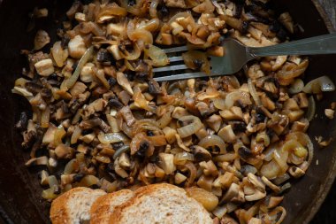 Mutfaktaki bir masada tavada kızarmış mantar.