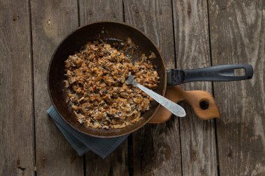 Mutfaktaki bir masada tavada kızarmış mantar.