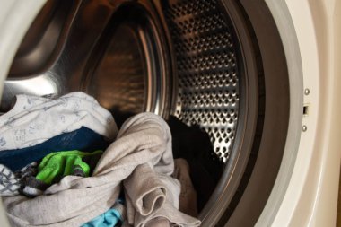 Yıkandıktan sonra temiz çocuk kıyafetlerinin çamaşır makinesinde tam depo