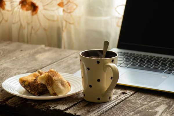 盘子里的凝块煎饼 木制桌子上的一杯茶和笔记本电脑 — 图库照片