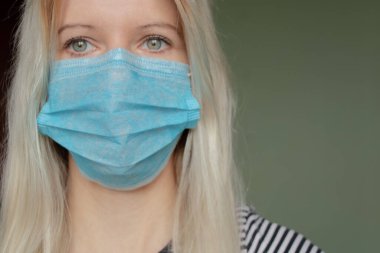 2020 'deki karantina salgını sırasında yüzünde tıbbi maske olan genç bir Ukraynalı kadının resmi.