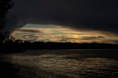 Gün batımında Dinyeper nehrinin üzerinde gök gürültülü bulutlar