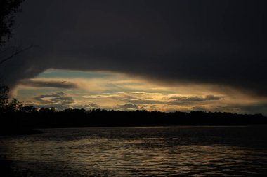 Gün batımında Dinyeper nehrinin üzerinde gök gürültülü bulutlar