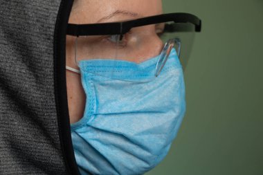 Sadece tıbbi maskeli ve güvenlik gözlüklü bir kız.