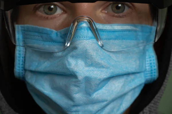 girl in a medical mask and safety glasses alone