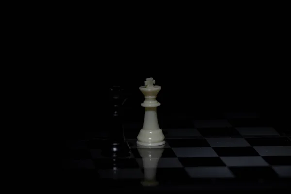 Шахматные Фигуры Шахматной Доске Темной Комнате Освещенной Фонарем — стоковое фото