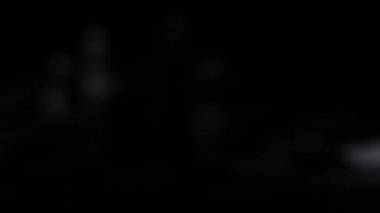 Bir fenerle aydınlatılmış karanlık bir odada satranç tahtasında satranç taşları.