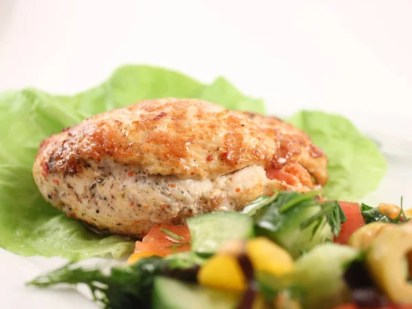 Stuffed chicken breast on lettuce, with fresh vegetable salad, close-up — Stockfoto