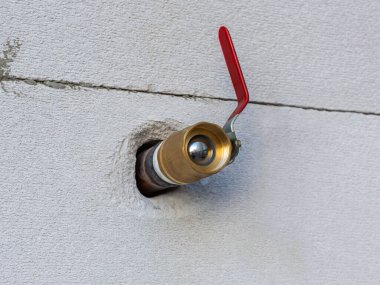 Duvardaki delikten bir gaz borusu çıkıyor ve sonunda bir musluk var. Kırmızı vana. Sol görünüm