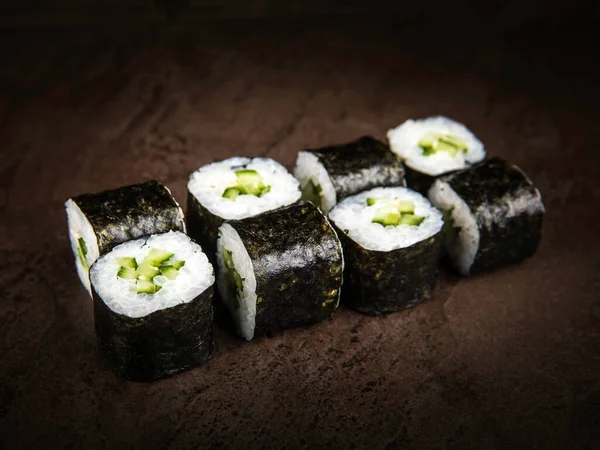 A portion of Japanese rolls, rice with avocado slices wrapped in nori seaweed, close-up. Selective focus