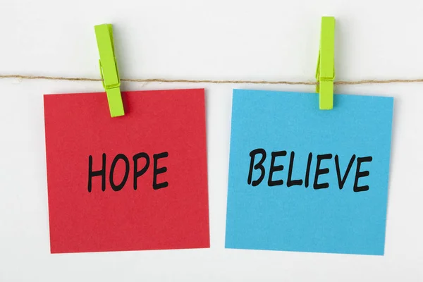 Esperança e acreditar escrito em nota com um conceito pitada — Fotografia de Stock