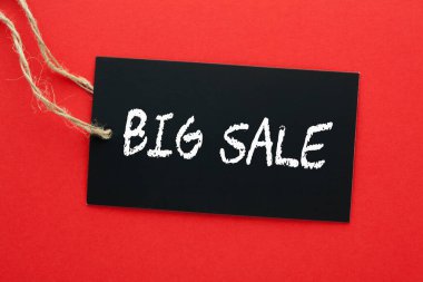 Kırmızı arka planda asılı siyah etikette büyük indirim.. 