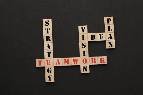 黒の背景に木製のブロックで単語戦略 チームワーク ビジョン アイデアや計画とのクロスワード — ストック写真
