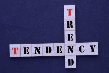 Kelime eğilimli bulmaca ve koyu arkaplanda tahta bloklardaki eğilim.