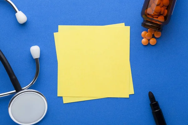 Blank Yellow Note Stethoscope Pills Various Stationery Blue Background Space — Stock Photo, Image